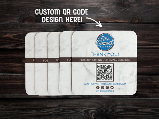 text says Custom QR code design here
image shows stack of custom QR code square coaster spread out on a dark wooden table